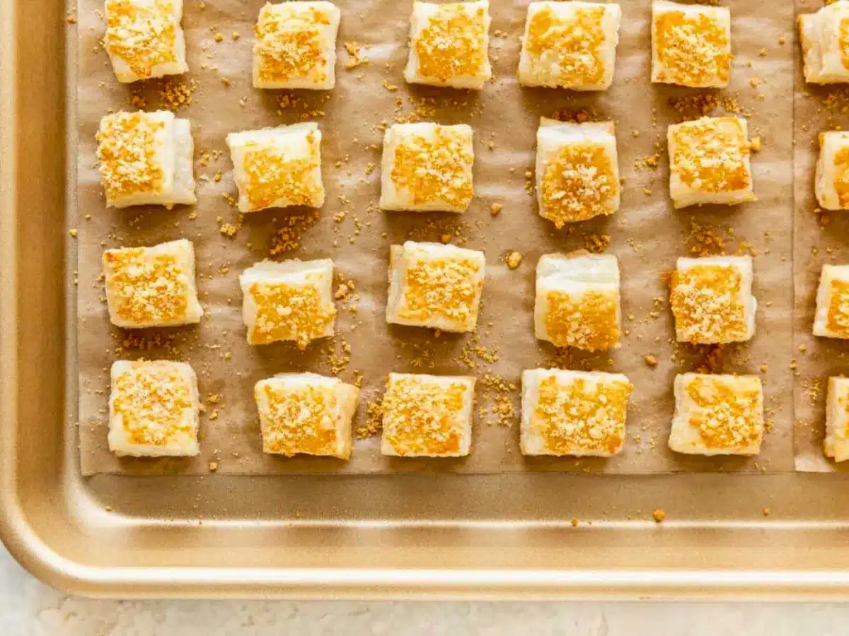 Cheese pastries lined on baking sheet