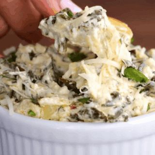 creamy greens mixed with cheese in a bowl and on a cracker