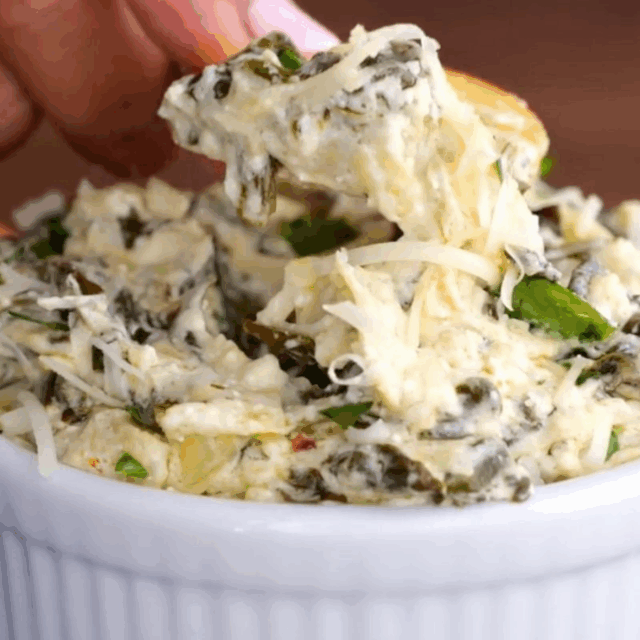 creamy greens mixed with cheese in a bowl and on a cracker