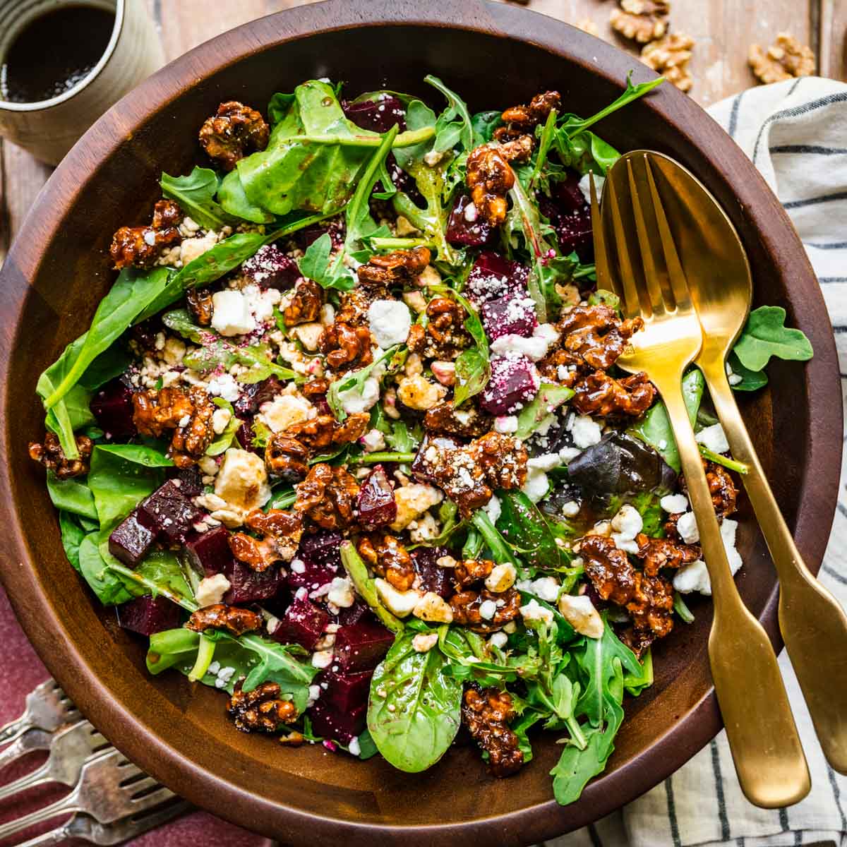 Beet and Goat Cheese Salad in wooden bowl with fork and spoon