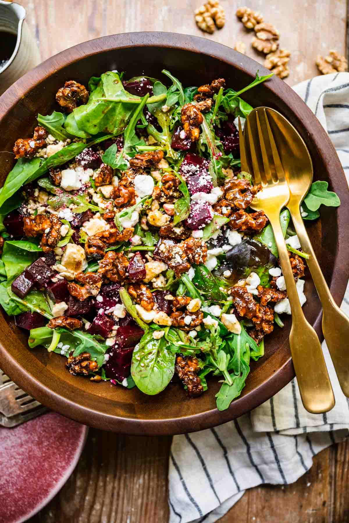 Beet and Goat Cheese Salad in wooden bowl with fork and spoon