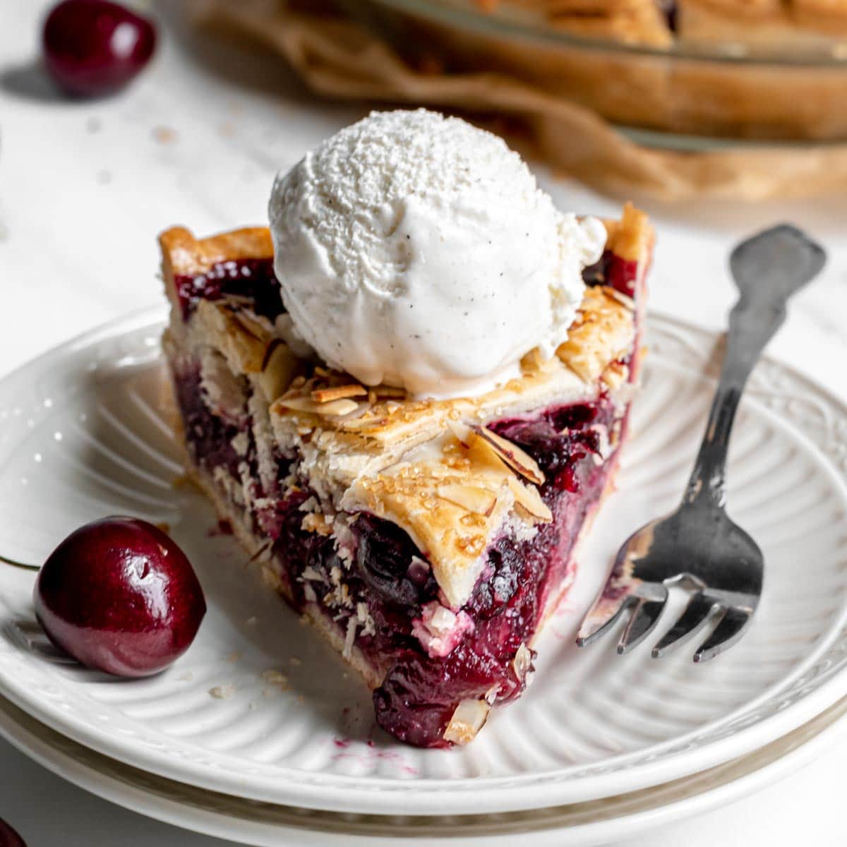 Cherry Almond Pie slice on plate with ice cream on top