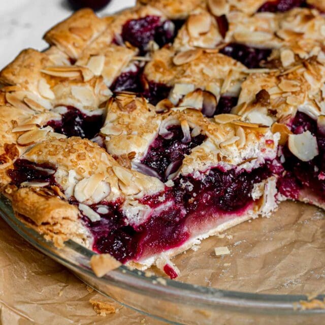 Cherry Almond Pie in pie dish with slice removed.