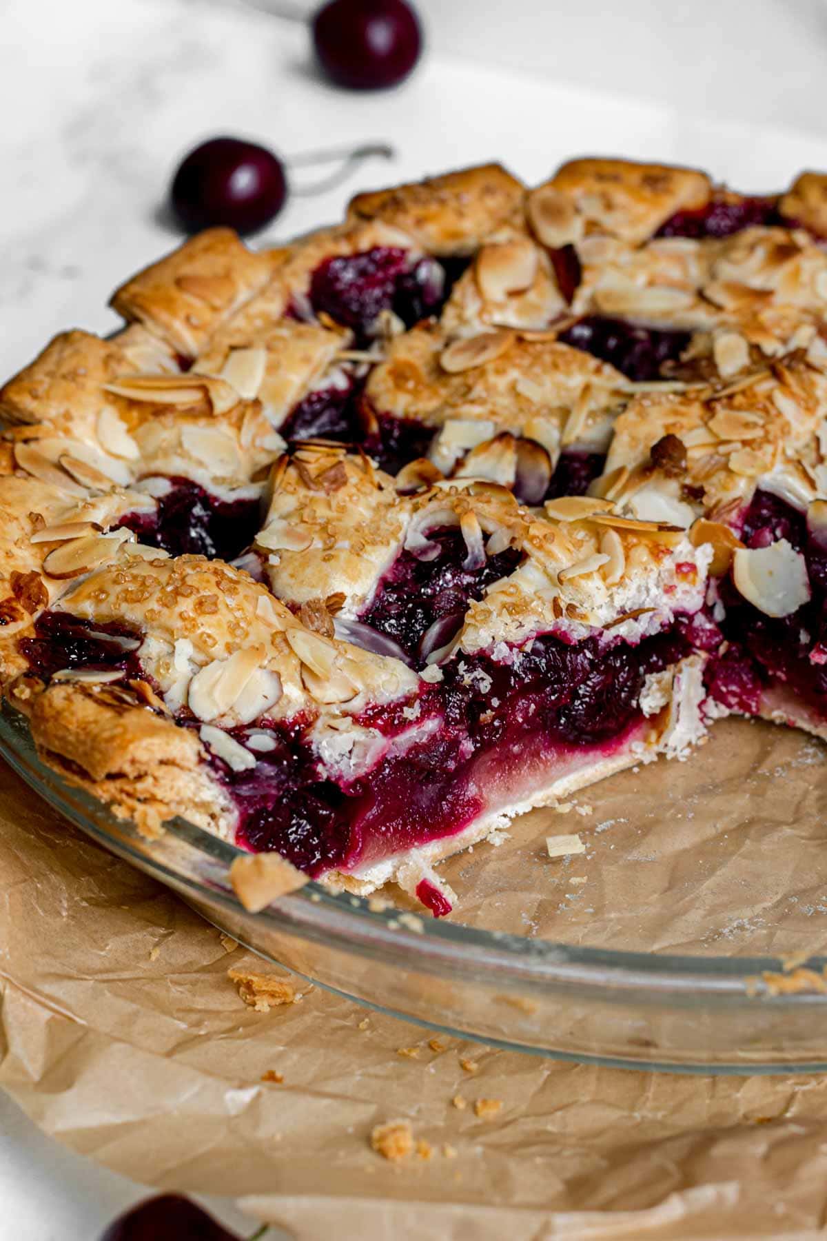 Cherry Almond Pie in pie dish with slice removed.