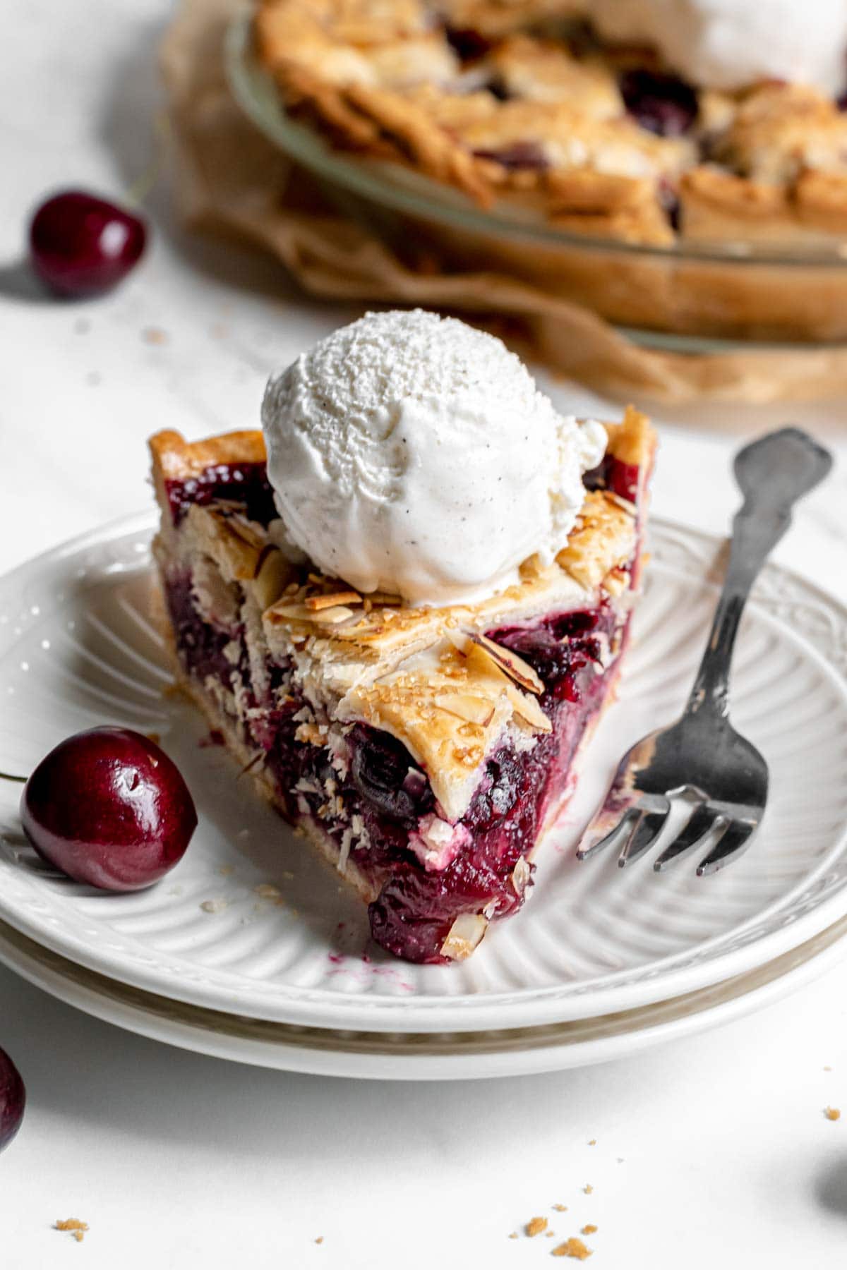 Cherry Almond Pie slice on plate with ice cream on top