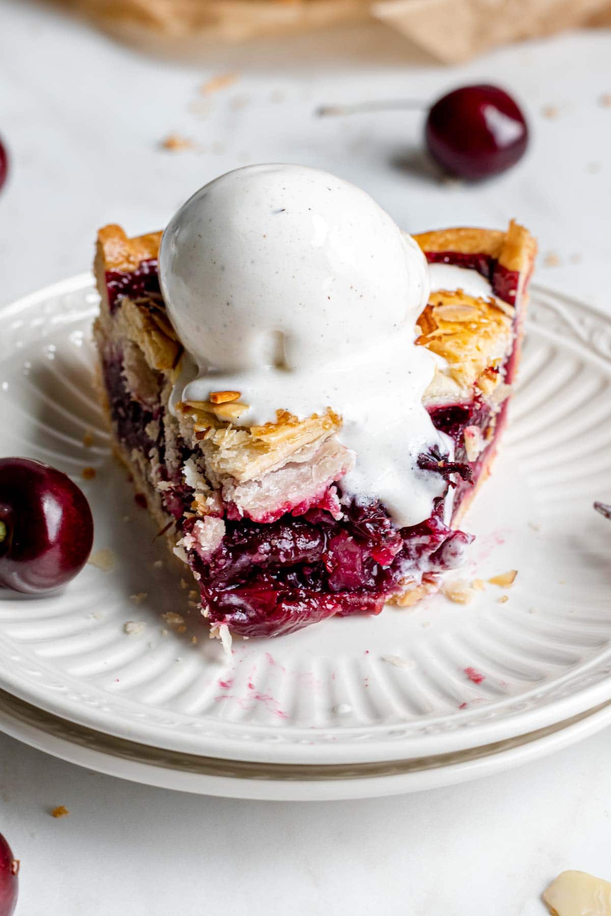 Cherry Almond Pie slice on plate with ice cream on top