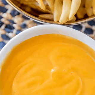 creamy sauce in a bowl with fries in a bowl on a table
