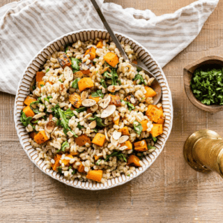 cooked grains in a pot with green and orange vegetables