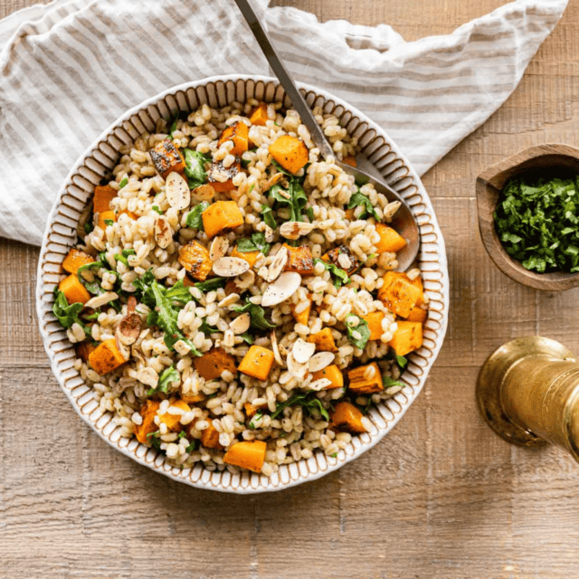 cooked grains in a pot with green and orange vegetables