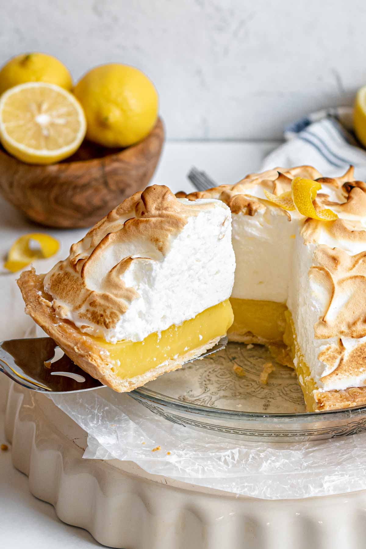 Lemon Meringue Pie in dish Side View slice removed on spatula