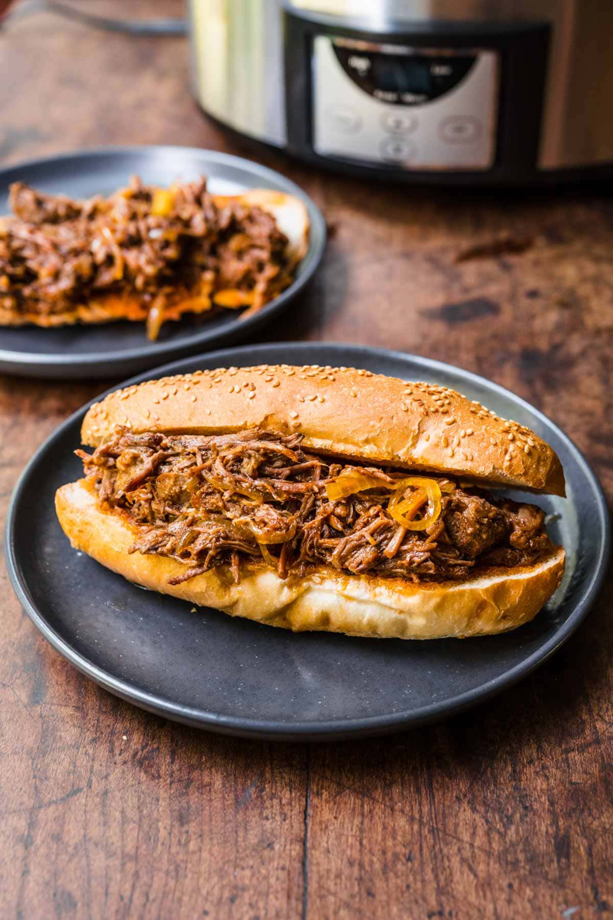 Slow Cooker Shredded Beef filling in hoagie roll on plate