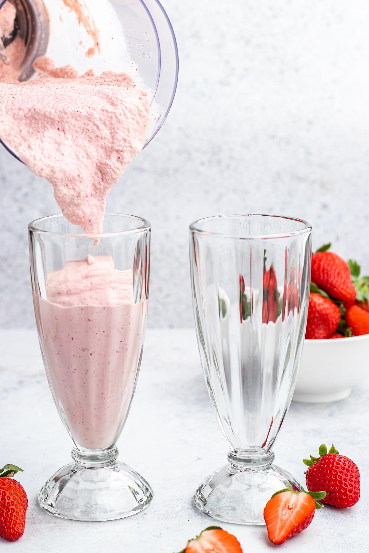 Strawberry Milkshake being poured in glasses