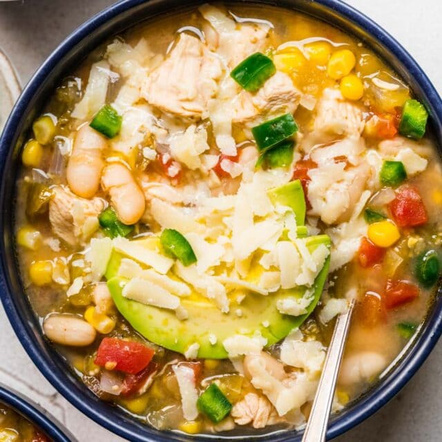 Chicken Chili with white beans in bowl with spoon.