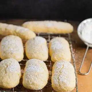 Powdered sugar dusted cookies on cooling rack.