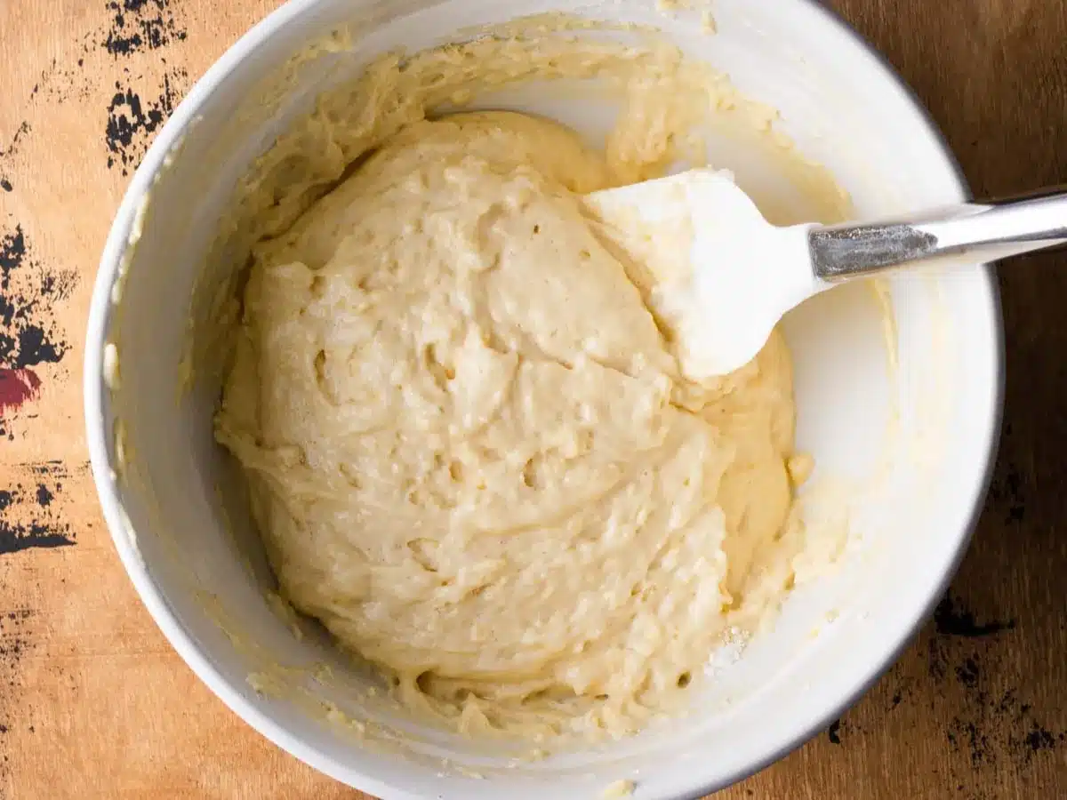 Raw dough in mixing bowl with spatula.