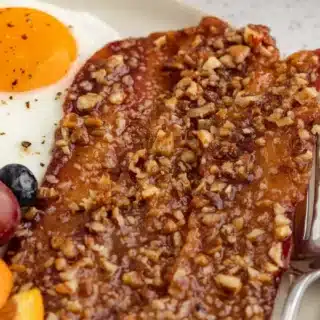 Sweet and crunchy coated bacon strips on plate.