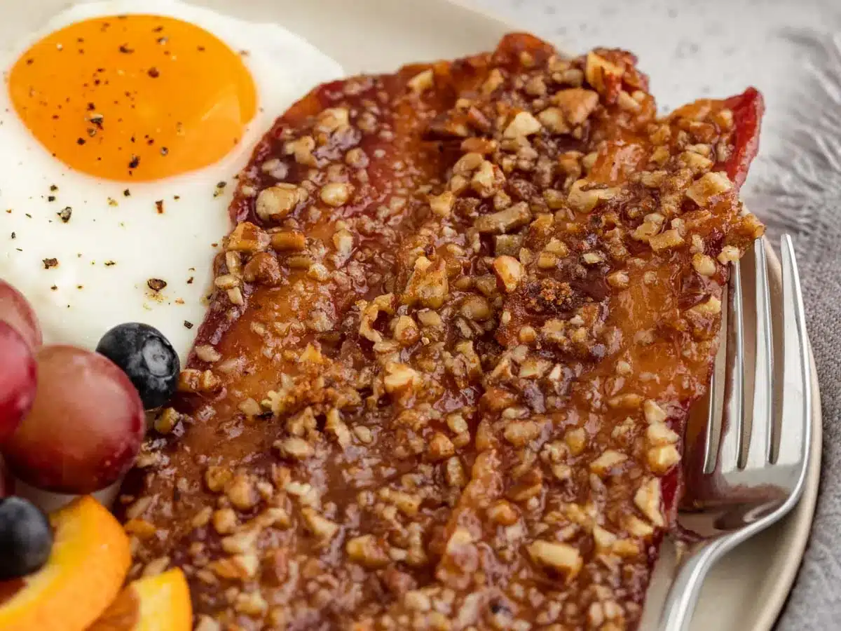 Sweet and crunchy coated bacon strips on plate.