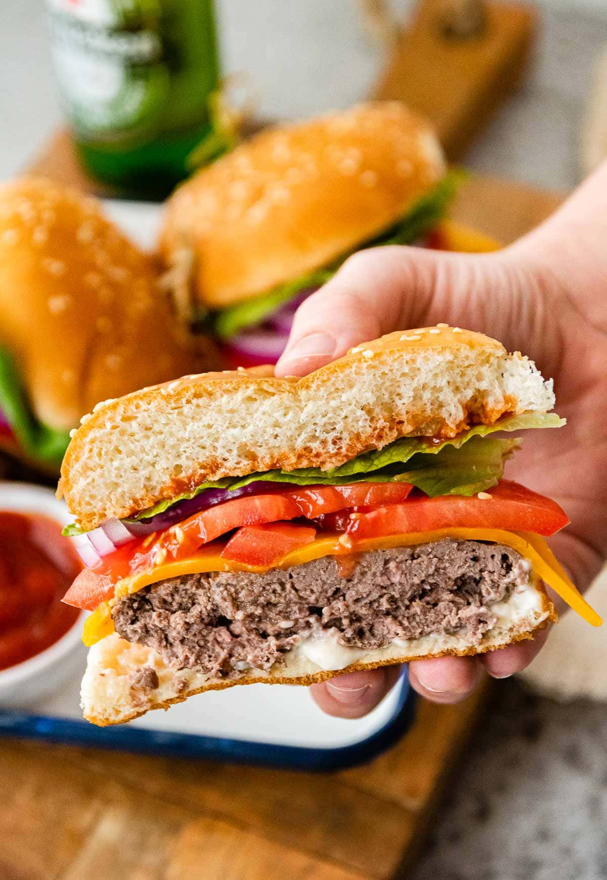 Air Fryer Cheeseburgers cut in hand