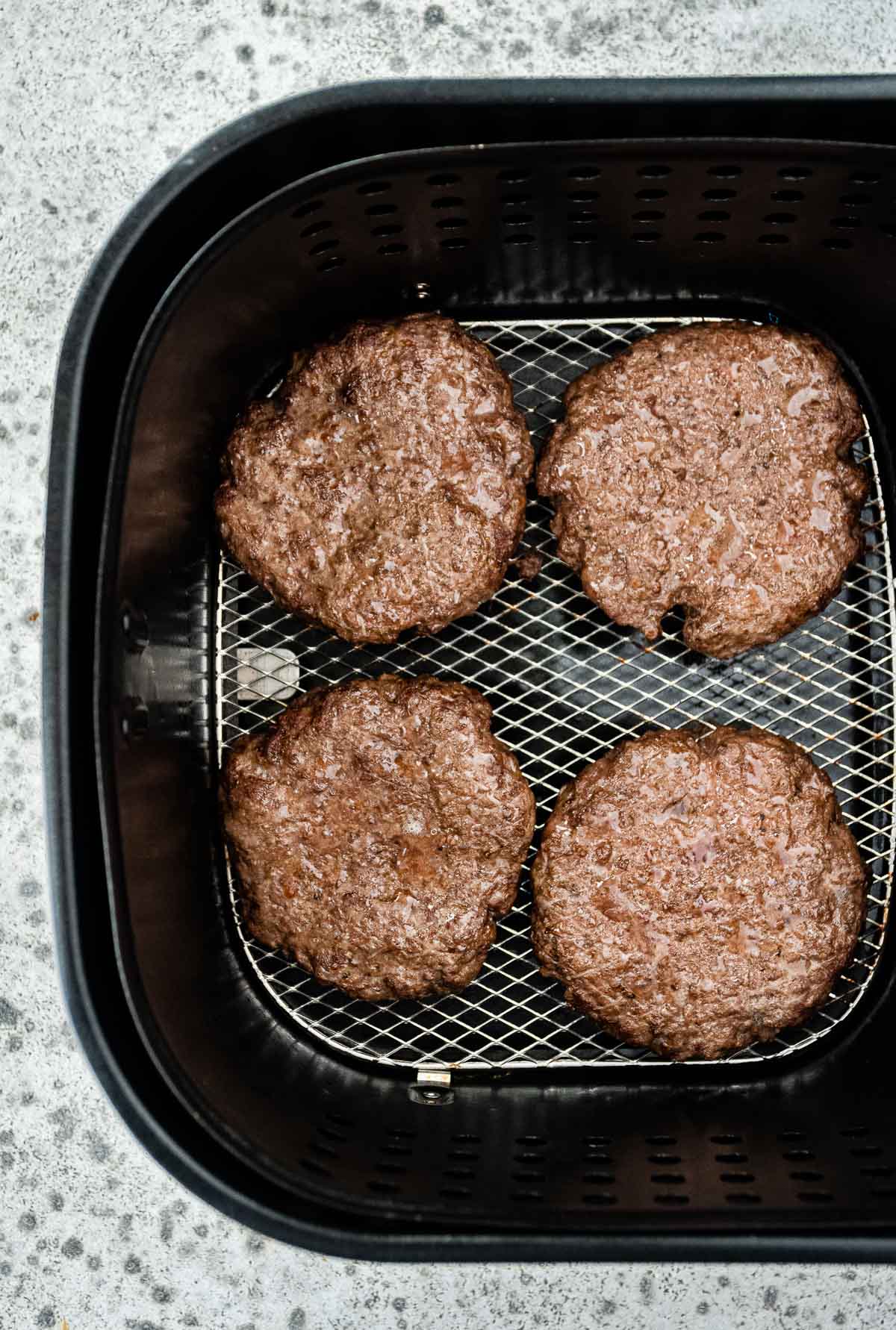 Air Fryer Cheeseburgers cooked patties in air fryer