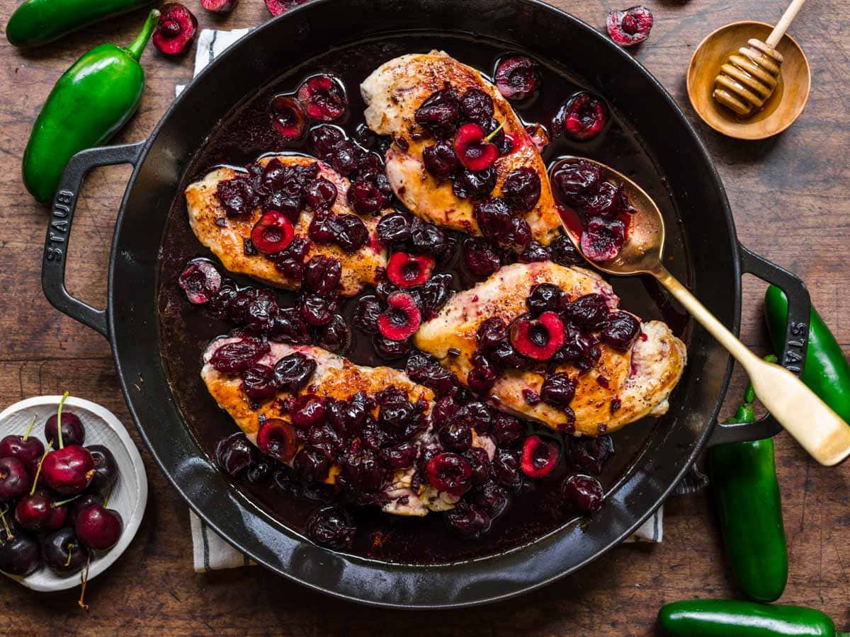 Chicken topped with cherry sauce in a pan