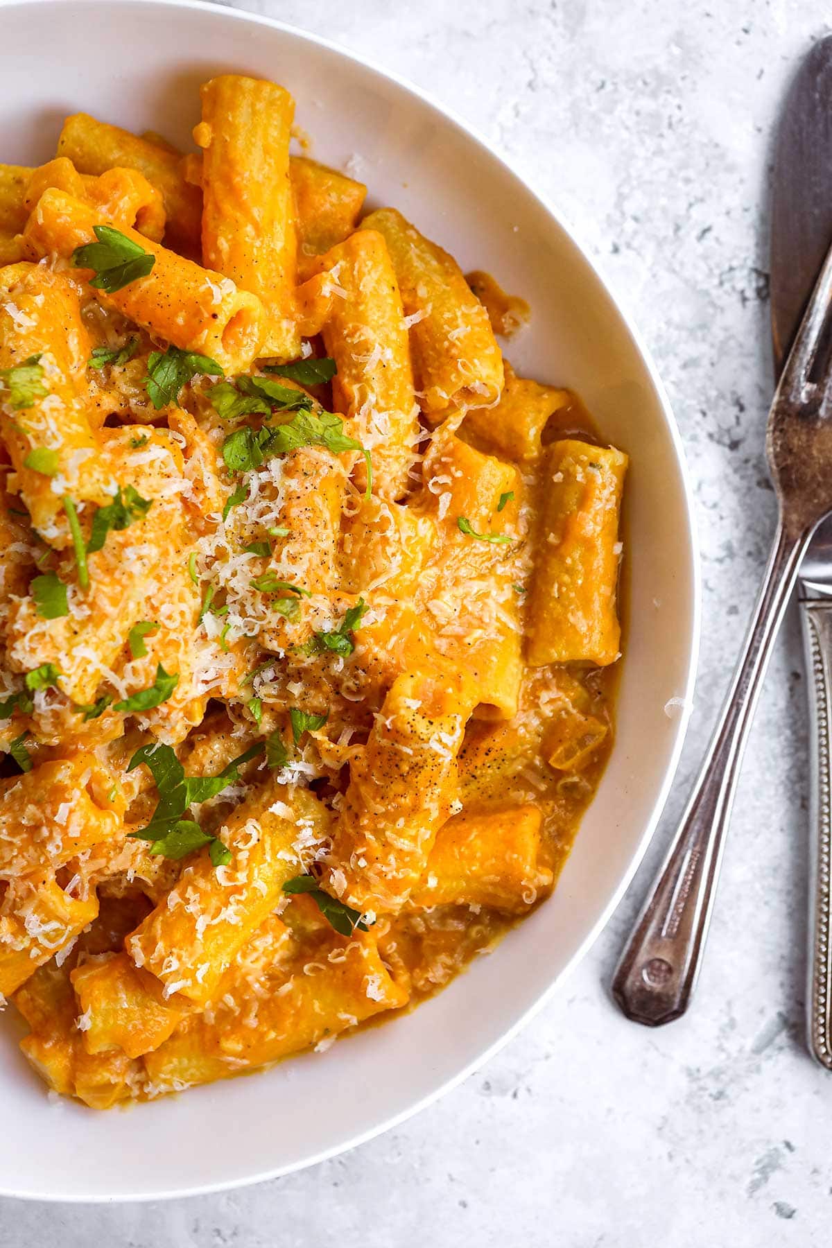 Creamy Pumpkin Pasta in bowl topped with Parmesan cheese and parsley