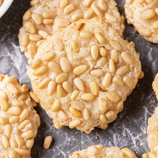 Close up of baked cookies with pine nut topping.