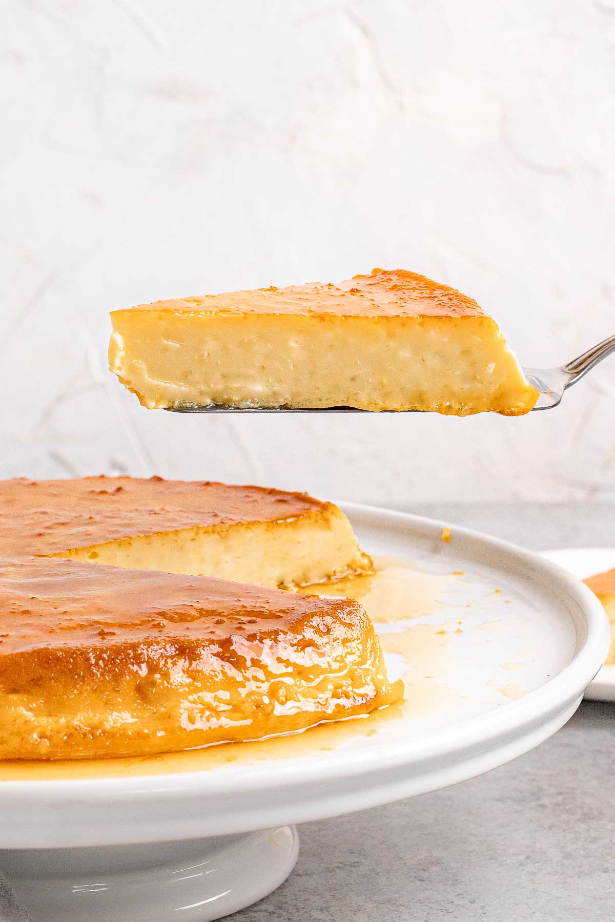 Mexican Caramel Flan on plate with slice removed on spatula