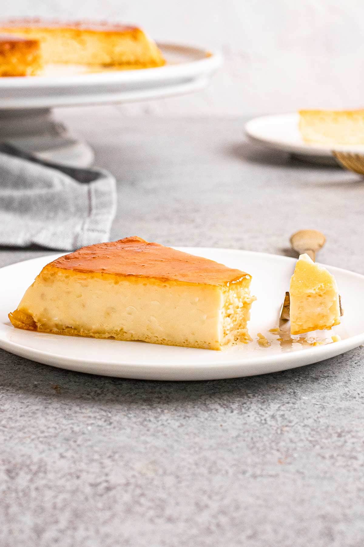 Mexican Caramel Flan slice on a plate with bite on fork