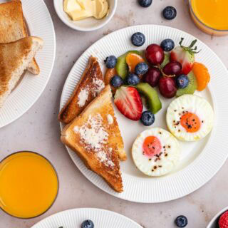 Breakfast plate with toast, fruit, and eggs.