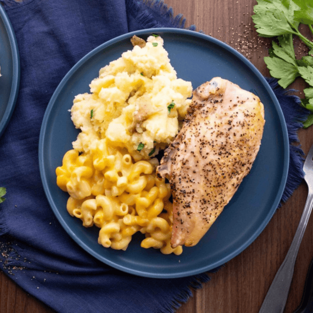 Chicken mashed potatoes and mac and cheese on blue plate