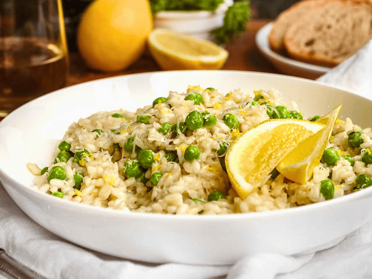 white plate of rice, peas, cheese, and lemon peel