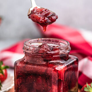 berry spread in a jar with a spoonful on top