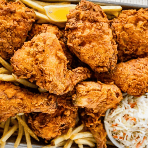 Multiple pieces of fried chicken with fries and coleslaw