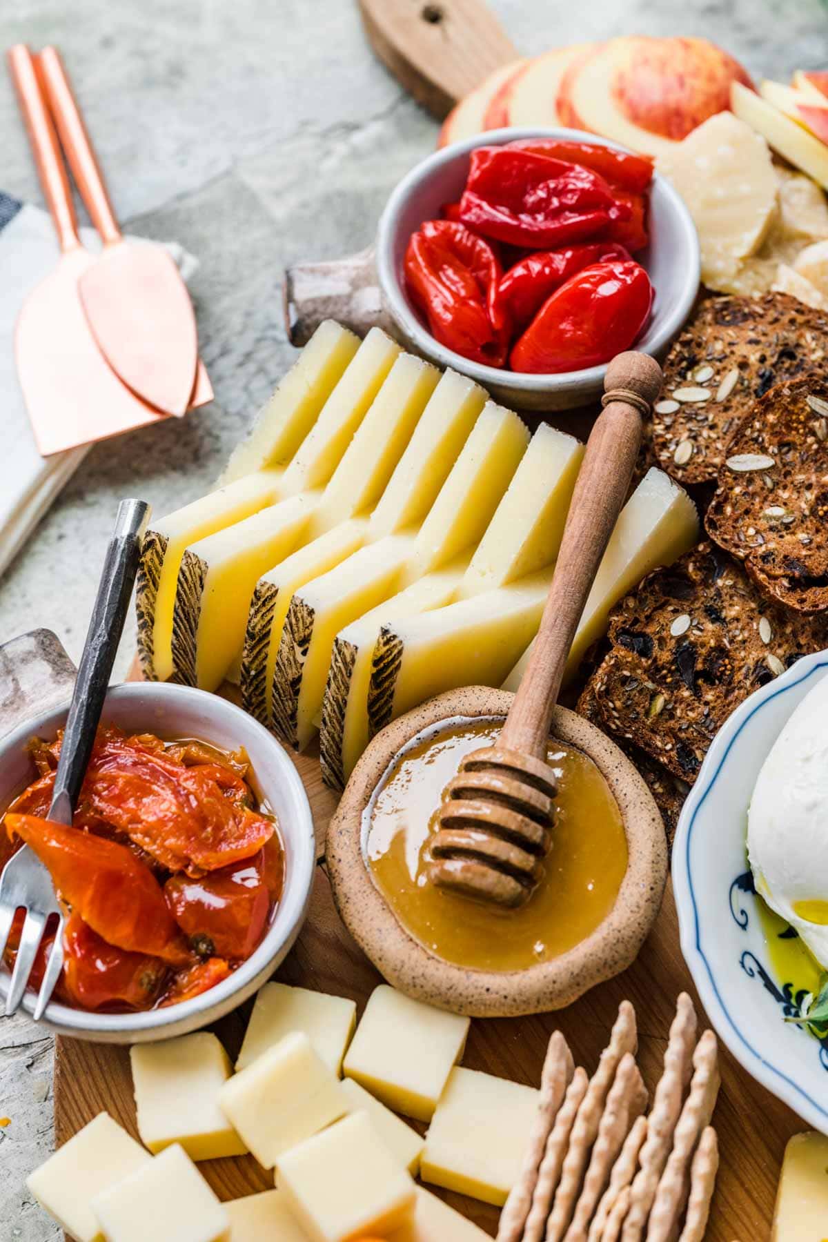 Cheese Board with crackers and accompaniments on round wood board.