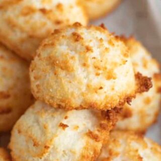 Coconut cookies stacked on a baking sheet