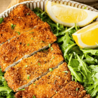 Cut chicken served on greens with lemon