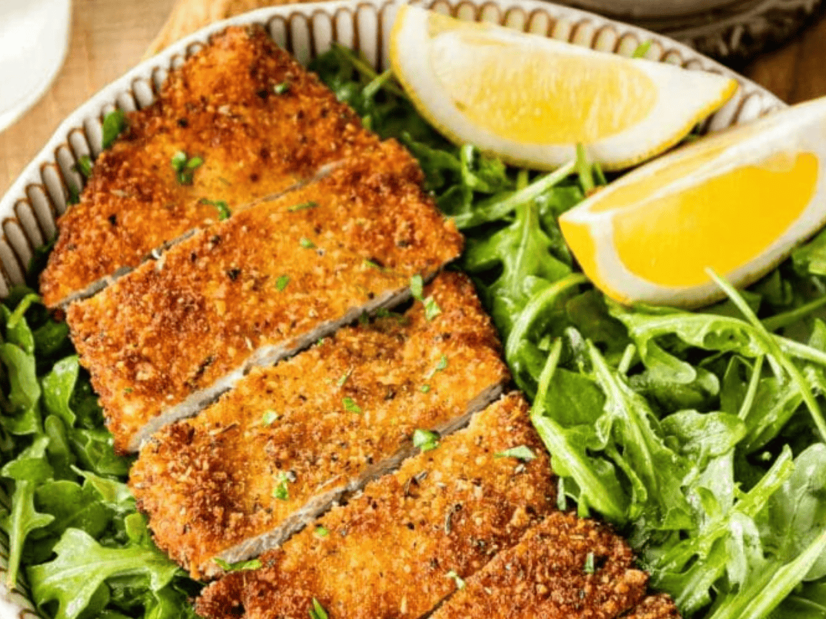 Cut chicken served on greens with lemon