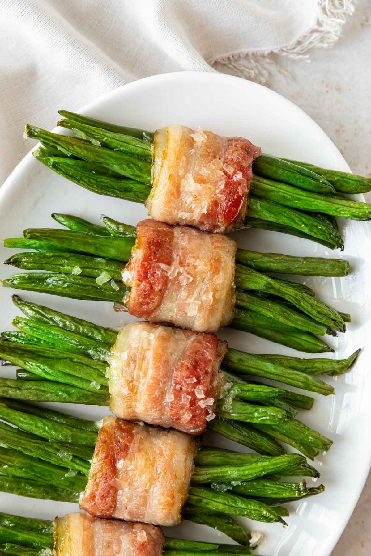Green Bean Bundles wrapped in bacon cooked on plate