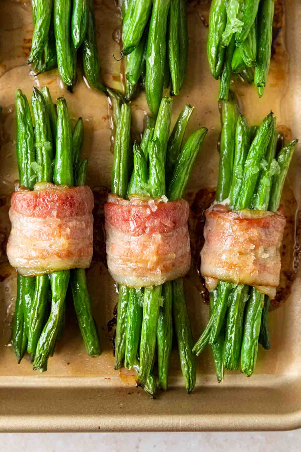Green Bean Bundles wrapped in bacon cooked on baking sheet