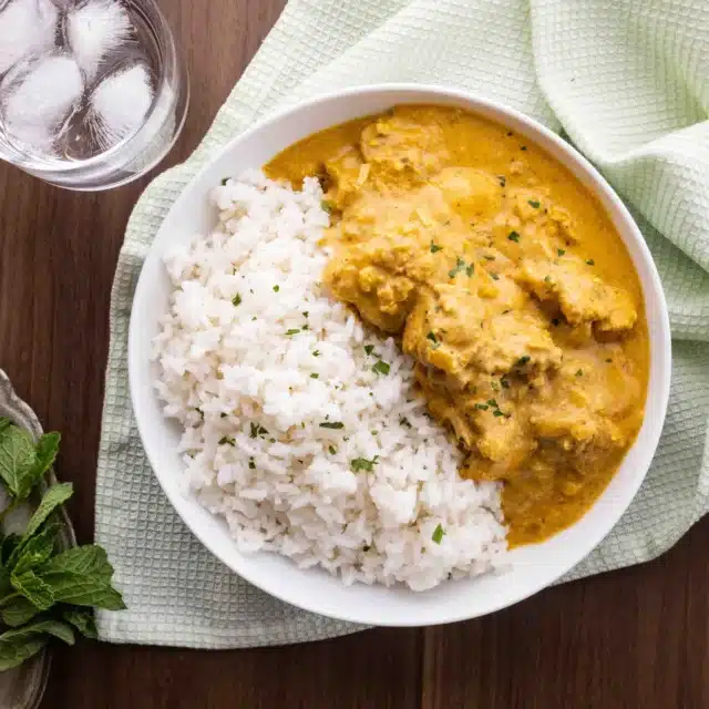 Cooked meat with a side of white rice served on a plate