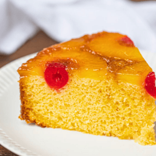 slice of cake on white plate with tropical fruits on it