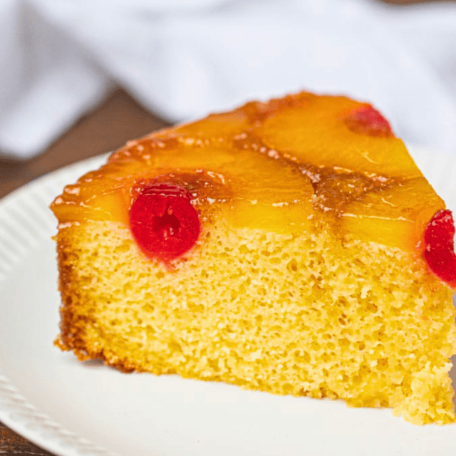 slice of cake on white plate with tropical fruits on it