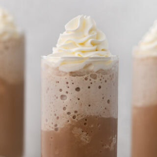 Frappuccino in glass with whipped cream.