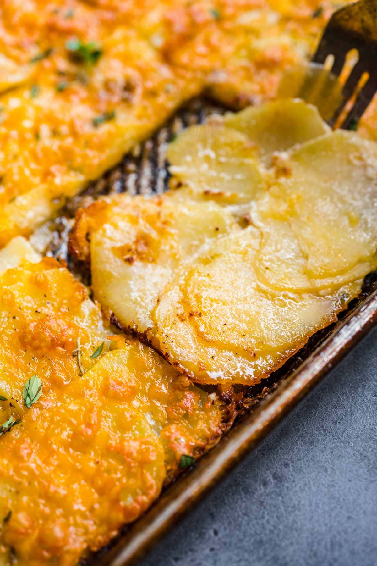 Sheet Pan Scalloped Potatoes finished close up of removing slice