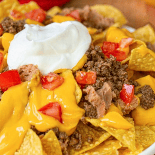 Plate of nachos with sour cream on top