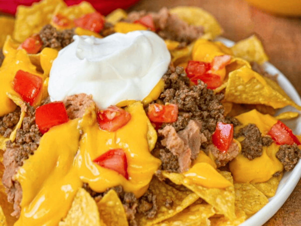 Plate of nachos with sour cream on top