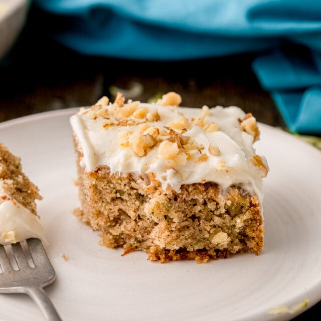 Zucchini Cake frosted slice on plate with bite on fork