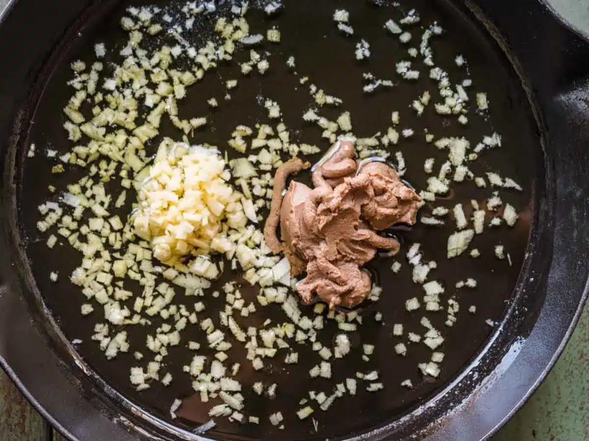 Oil, garlic, butter, and anchovy paste sautéing in pan.