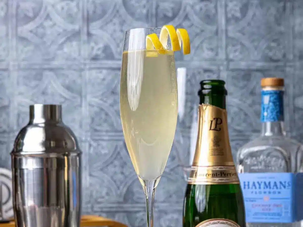 Champagne cocktail in flute with lemon garnish.
