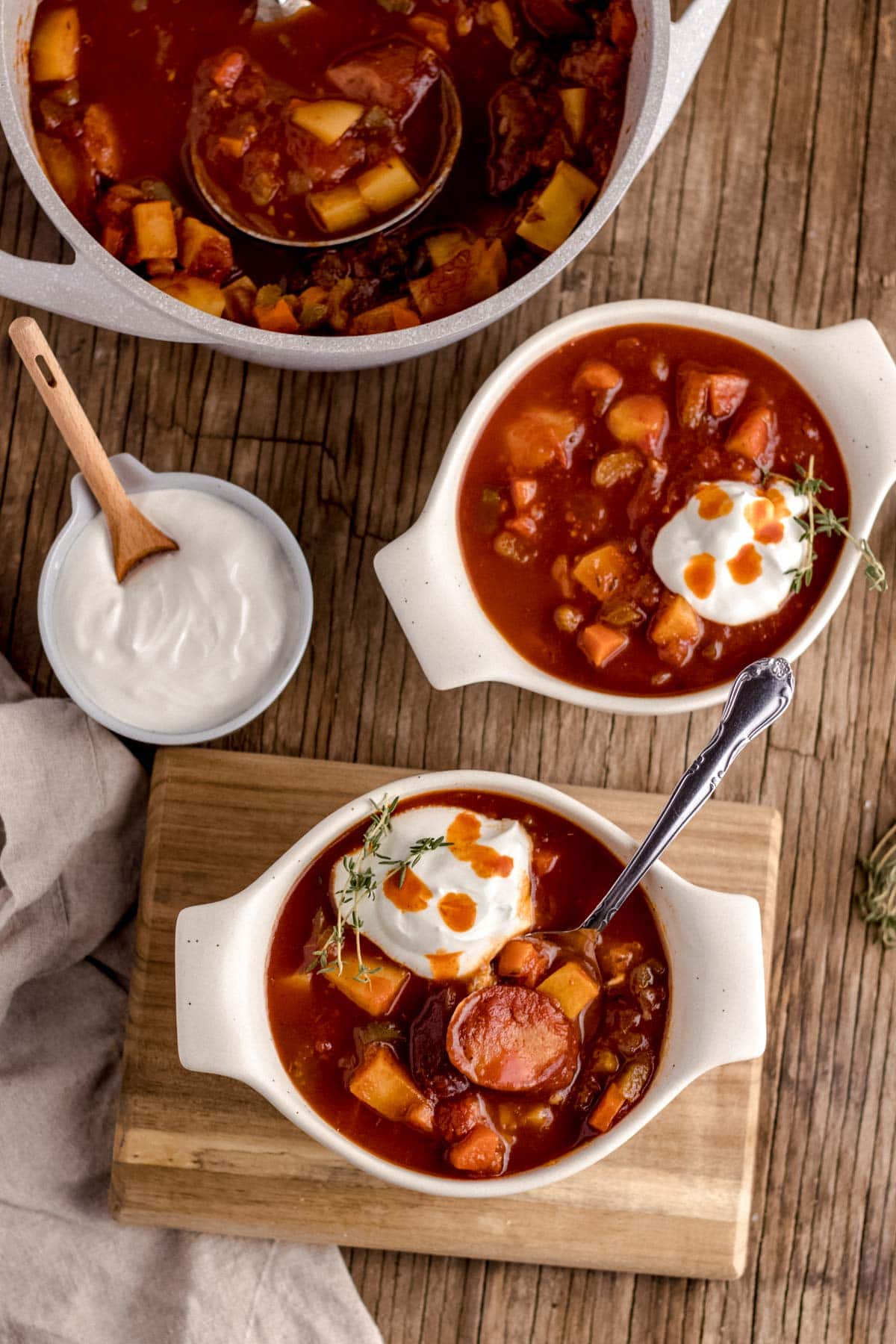 Andouille Sausage Soup in serving bowls with sour cream